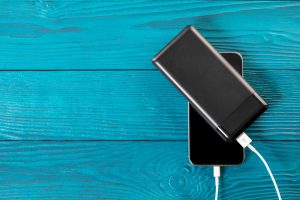 Powerbank,Charges,Smartphone,Isolated,On,Wood,Background